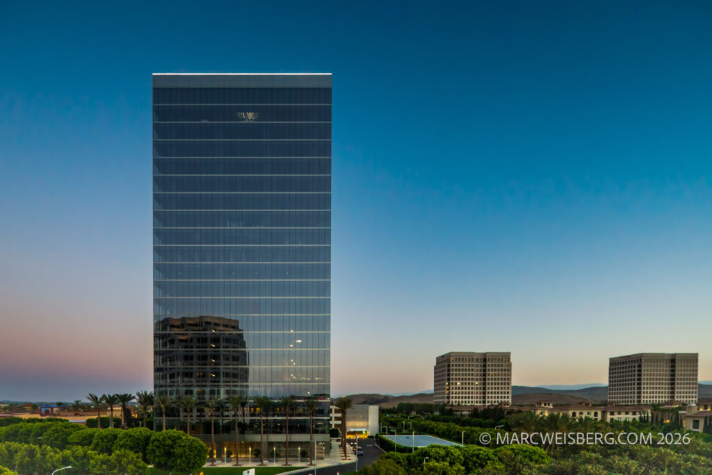 Commercial office tower at twilight reflecting surrounding buildings in Irvine, Orange County — architectural photography by Marc Weisberg