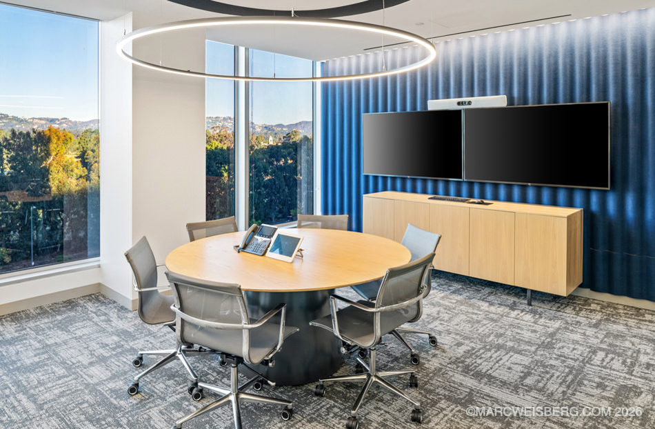 Law firm meeting room with round table and blue accent wall in Century City