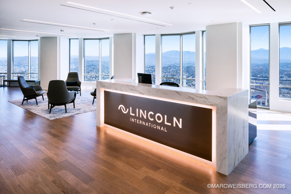 Reception desk with lit Lincoln International logo in a Los Angeles office