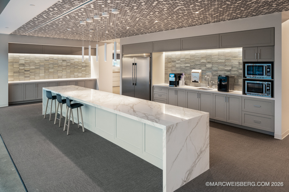 Office kitchen with marble waterfall island and textured ceiling