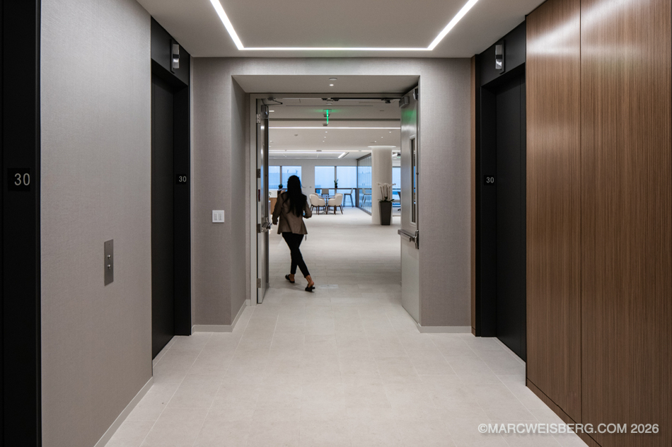 Elevator lobby with wood paneling leading into a high rise office